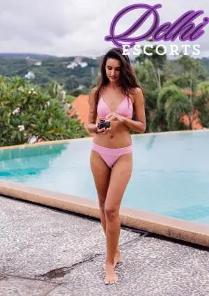 One Women Standing Near Swiming Pool Wearing Pink Dress, Talk About Delhi Escorts for Delhi Lifestyle Assistance